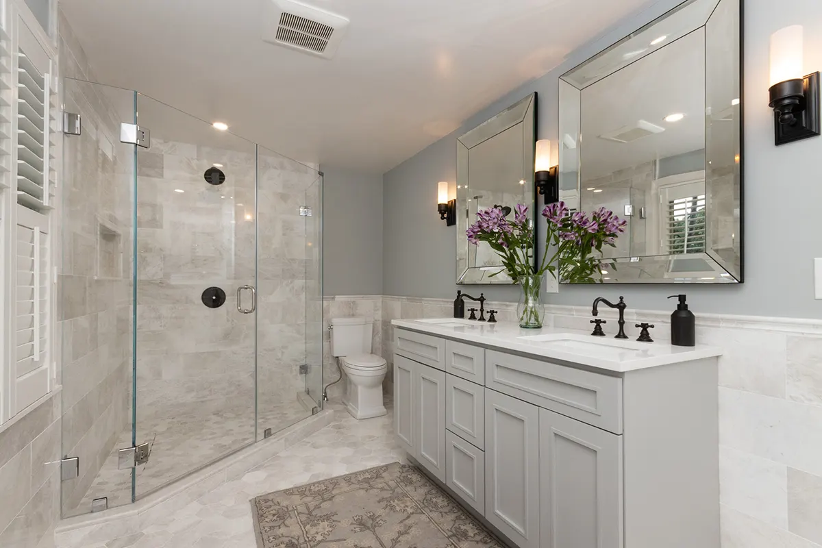 Renovated Needham primary bathroom on South Street with gray double vanity, marble shower, and plantation shutters