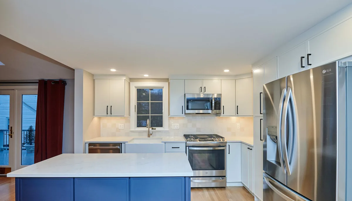 Renovated Wright Street kitchen in Arlington with white shaker cabinets, navy island, and stainless appliances