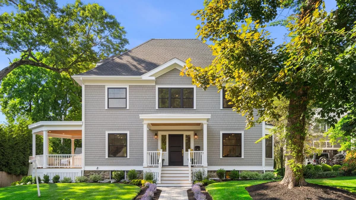 Renovated gray shingle-style Colonial on Sewall Street in Newton with white trim and a wraparound porch