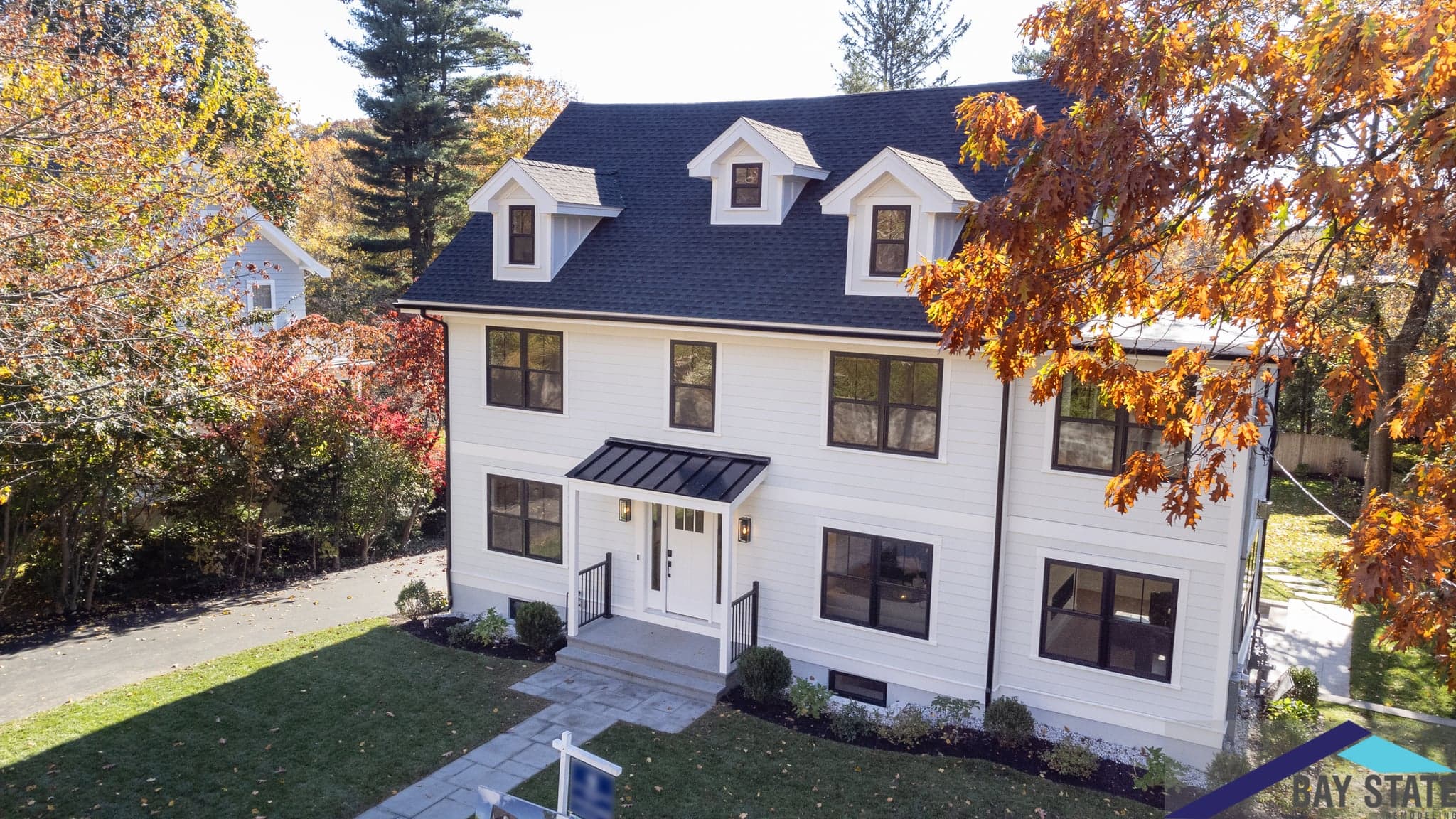 Mill St. Newton whole-home remodel with a cream-sided colonial, black roof and three dormer windows