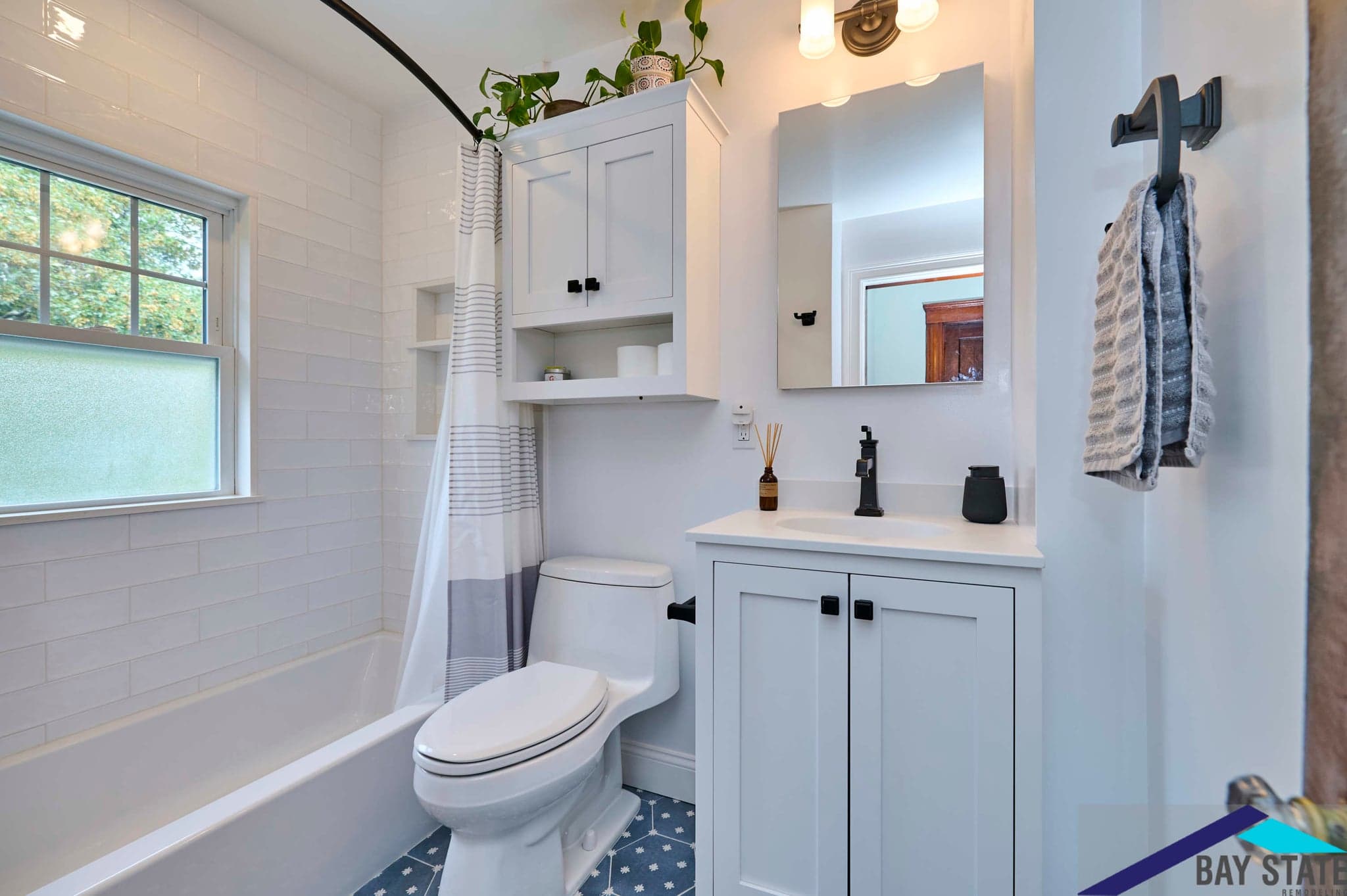 Renovated N. Crescent Circuit Boston bathroom with white subway tile tub and patterned blue floor tile