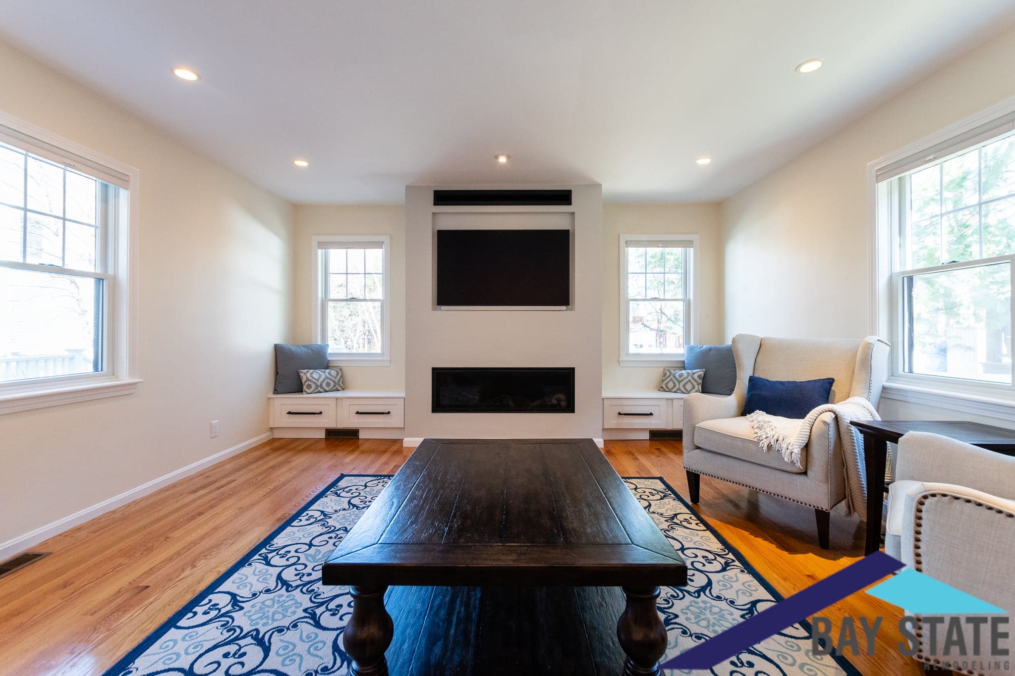 Rebecca Road Newton living room remodel with a fireplace, flanking window seats, and oak floors