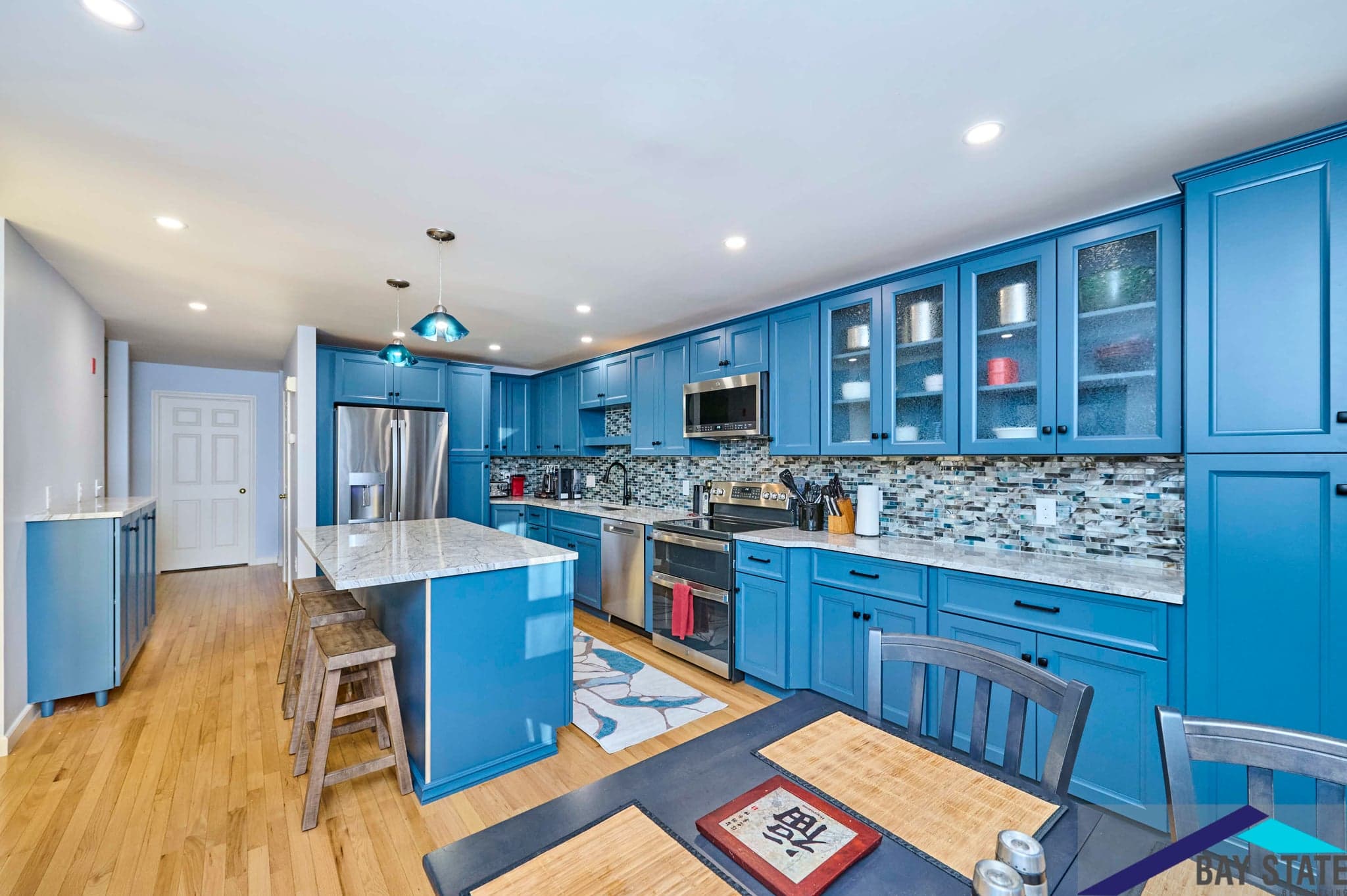 South Commons Lincoln kitchen with blue cabinets, mosaic backsplash tile, and white marble island countertop