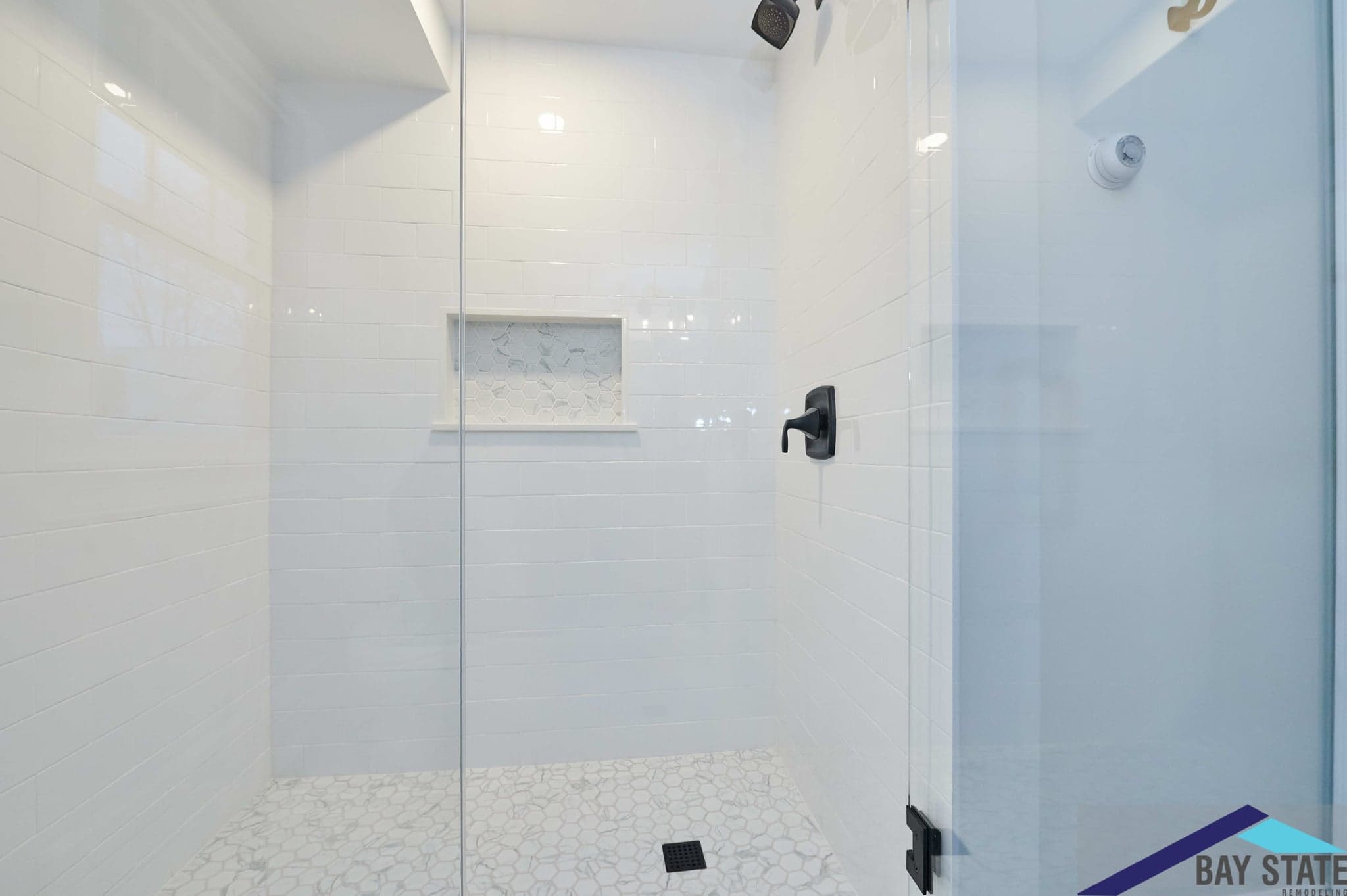 Renovated Wright St. Arlington shower with blue-gray tile, black fixtures, and a patterned tile niche