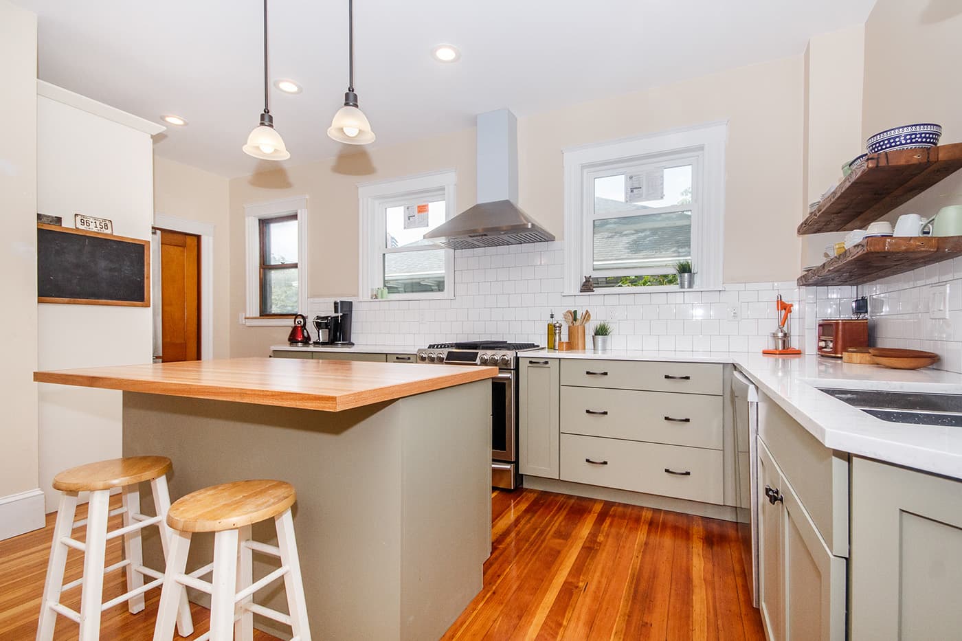 Bynner St. Jamaica Plain kitchen with sage cabinets, white subway tile, and butcher block island