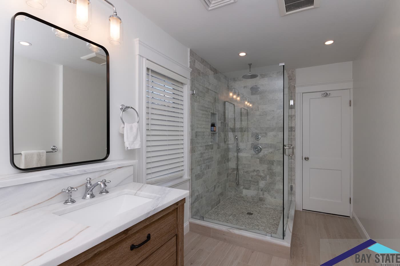 Renovated Clark Rd. Brookline bathroom with gray stone tile walk-in shower and wood vanity