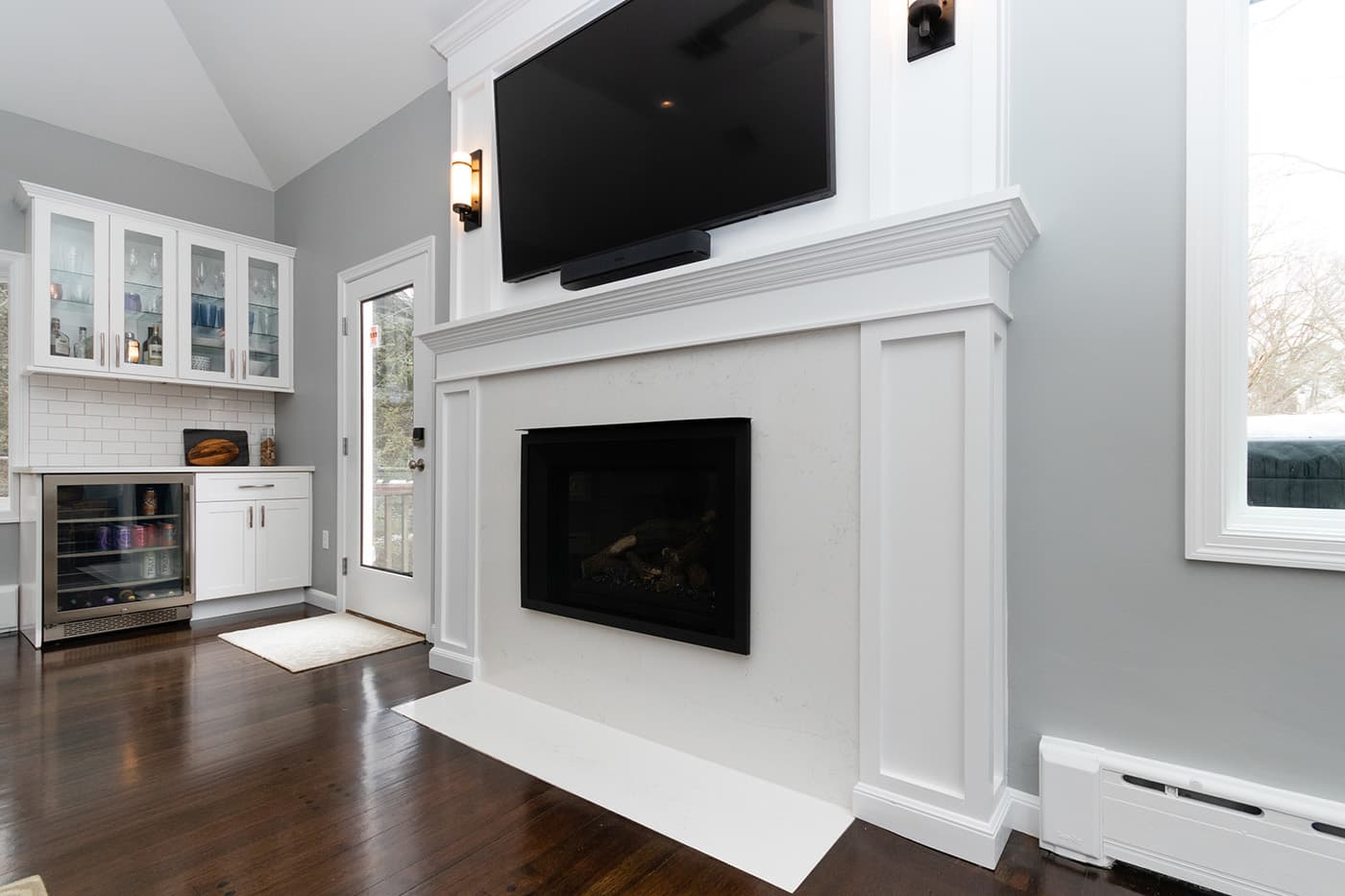 Renovated Columbine Rd. Milton living room with a fireplace, mounted TV, and black leather chairs