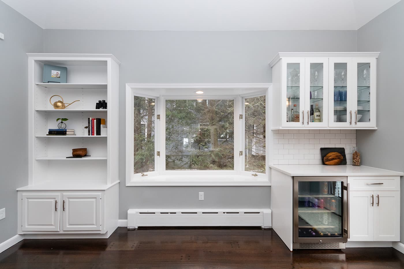 Renovated Columbine Rd. Milton living room features a white built-in bookshelf and bay window bench seat