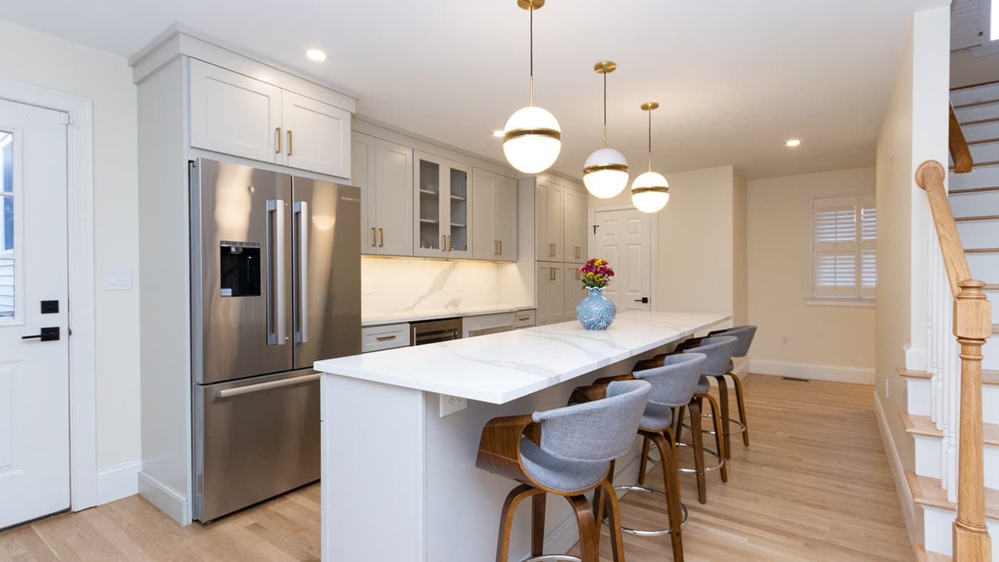 Forest Hills St. Jamaica Plain kitchen with gray cabinets, quartz island, and globe pendant lighting