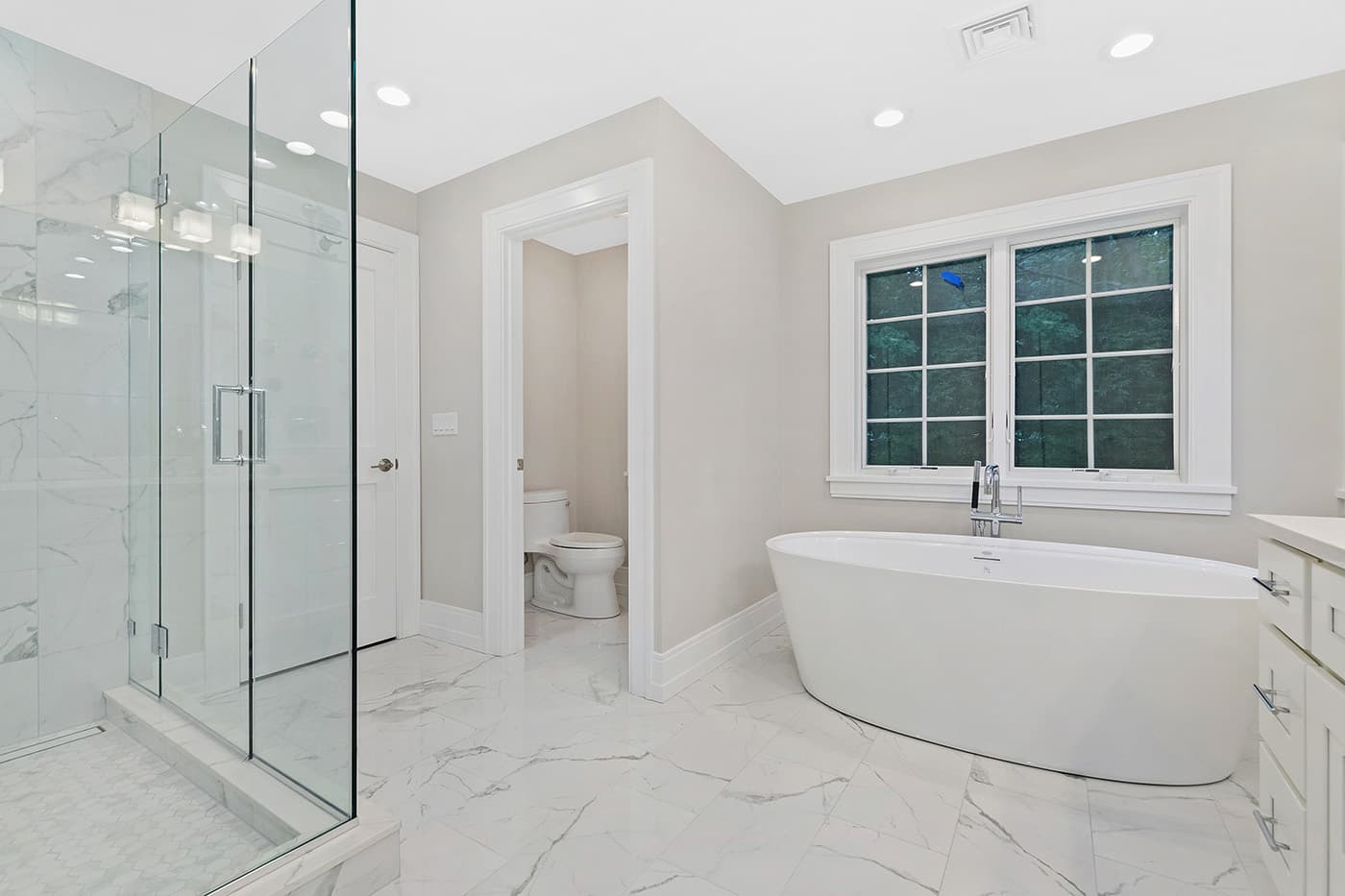 Renovated Garland Rd. Newton master bathroom with marble floor tile, glass shower, and separate water closet