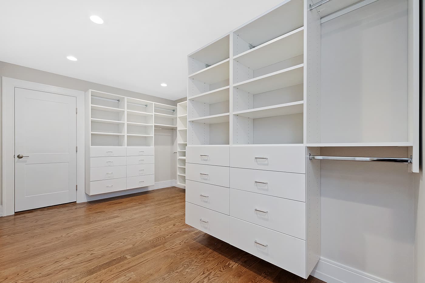 Garland Rd. Newton walk-in closet remodel with white built-in shelving, drawers, and hanging rods