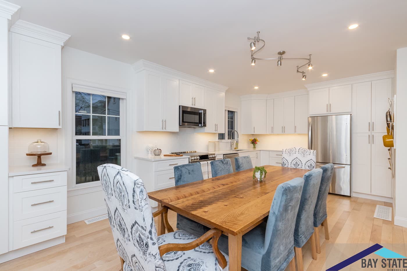 Harvey St. Cambridge kitchen with white cabinets, stainless fridge, and adjoining dining nook