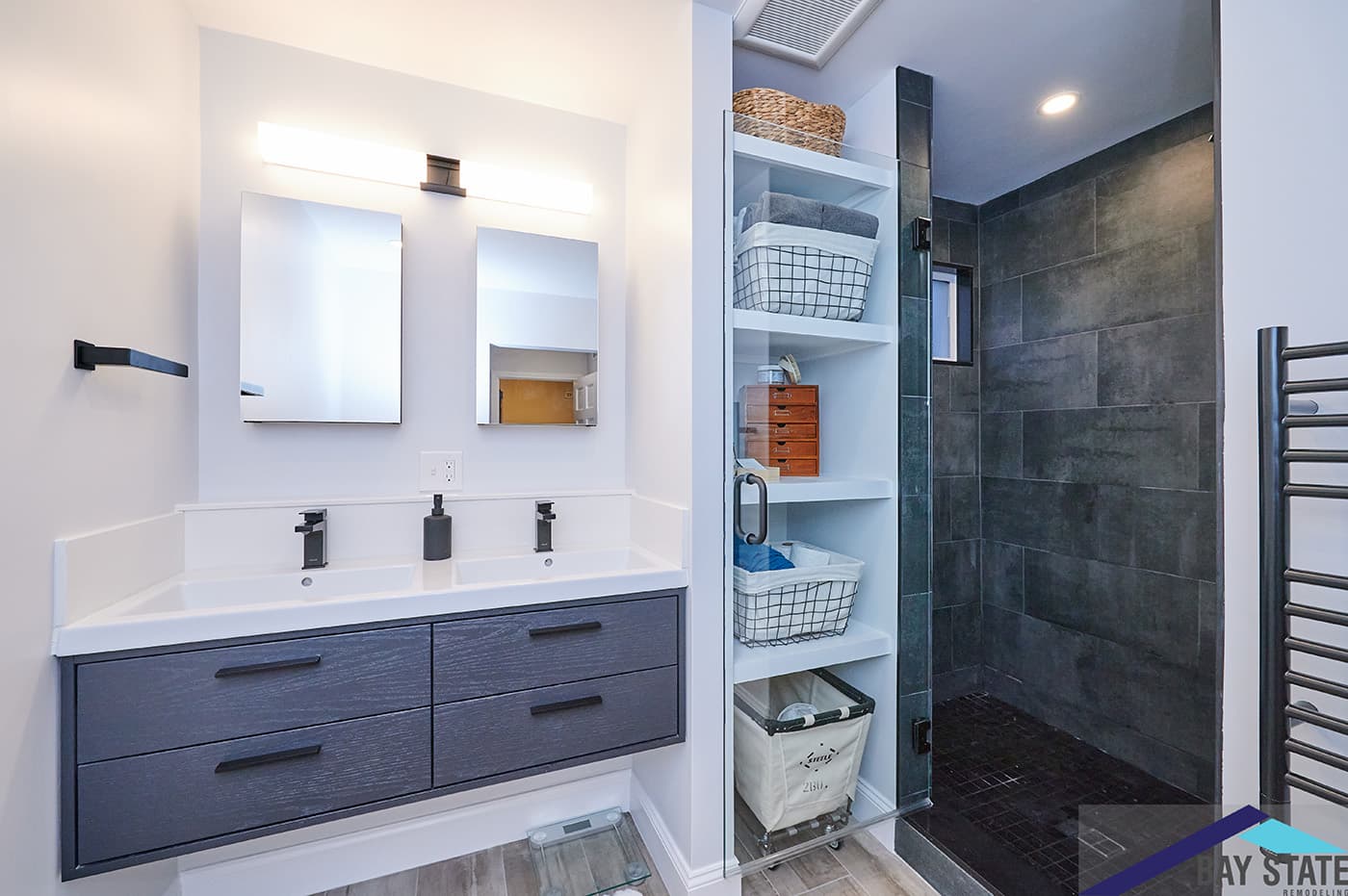 Renovated Hinckley St. Somerville bathroom with navy floating double vanity, black fixtures, and slate shower