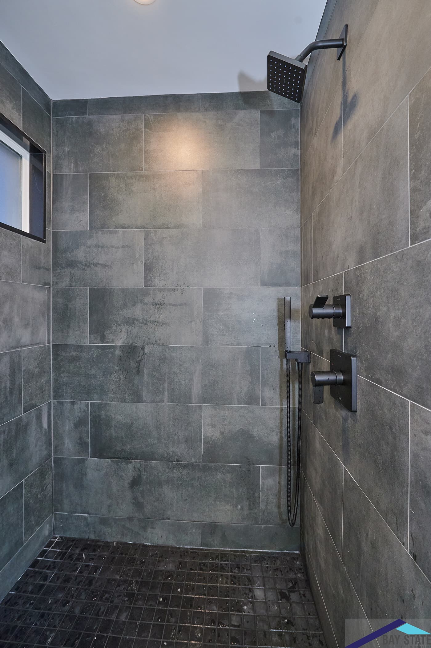 Hinckley St. Somerville walk-in shower with large-format charcoal gray tile and black fixtures