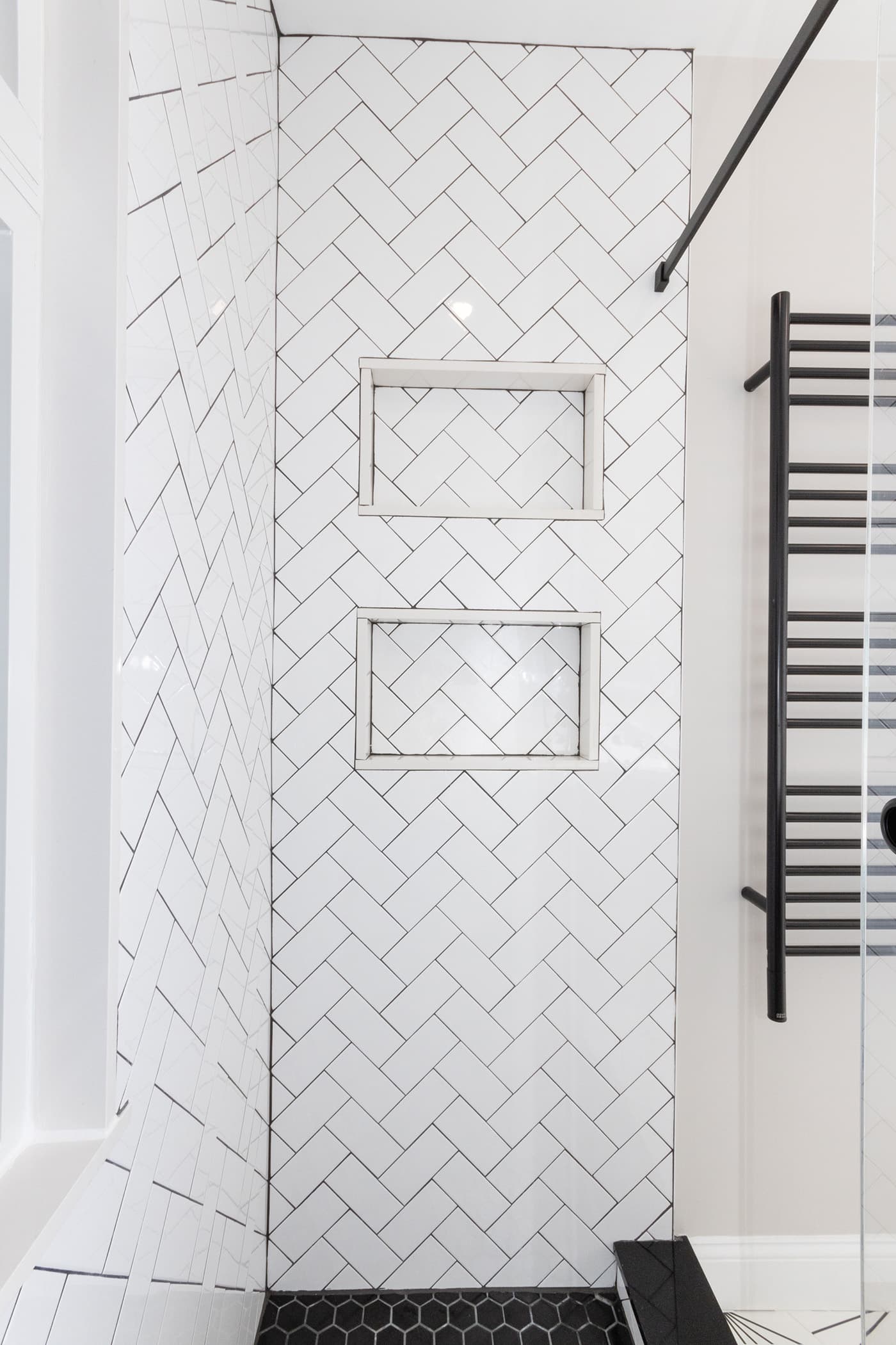 Hosmer St. Watertown shower wall with two white herringbone-tiled niches and a black towel rack