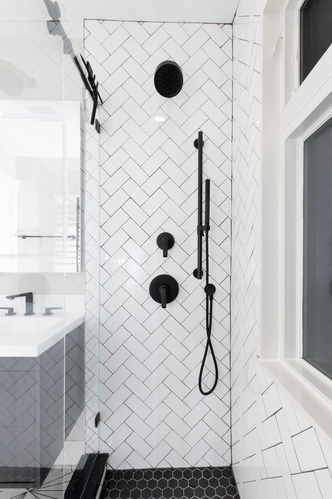 Hosmer St. Watertown shower with white herringbone tile and matte black fixtures and handles