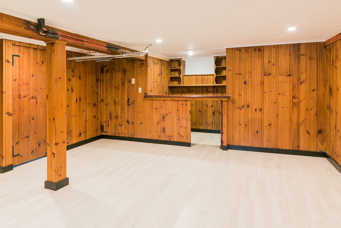 Madison St. Belmont basement finished with knotty-pine paneling, new tile flooring, and built-in corner shelving