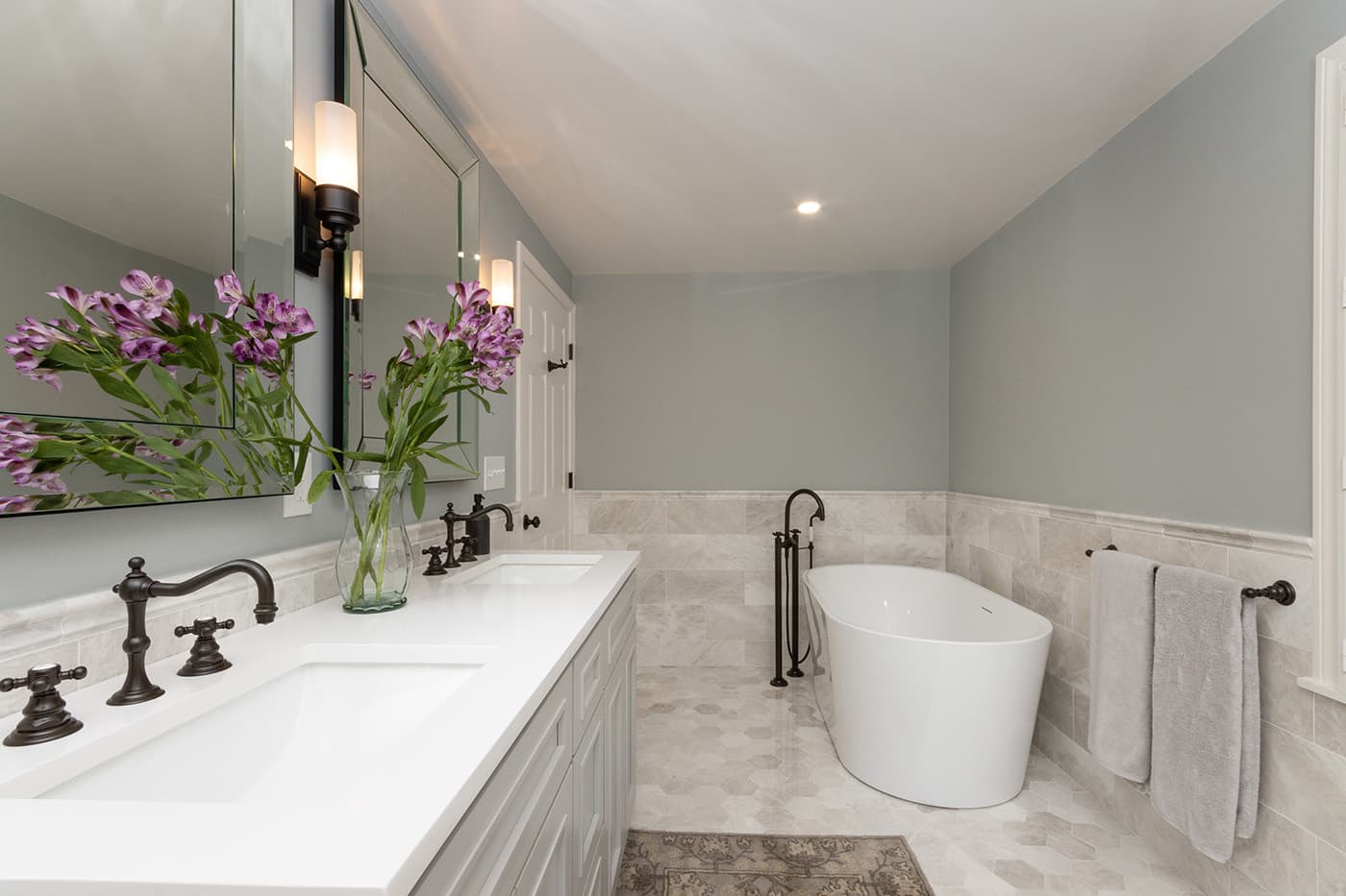 Renovated South St. Needham bathroom with a double vanity, oil-rubbed bronze fixtures, and freestanding soaking tub