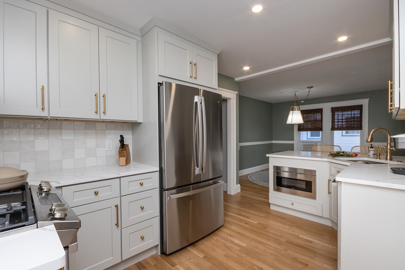 Thurlow St. West Roxbury kitchen with white cabinets, quartz counters, and gold hardware accents