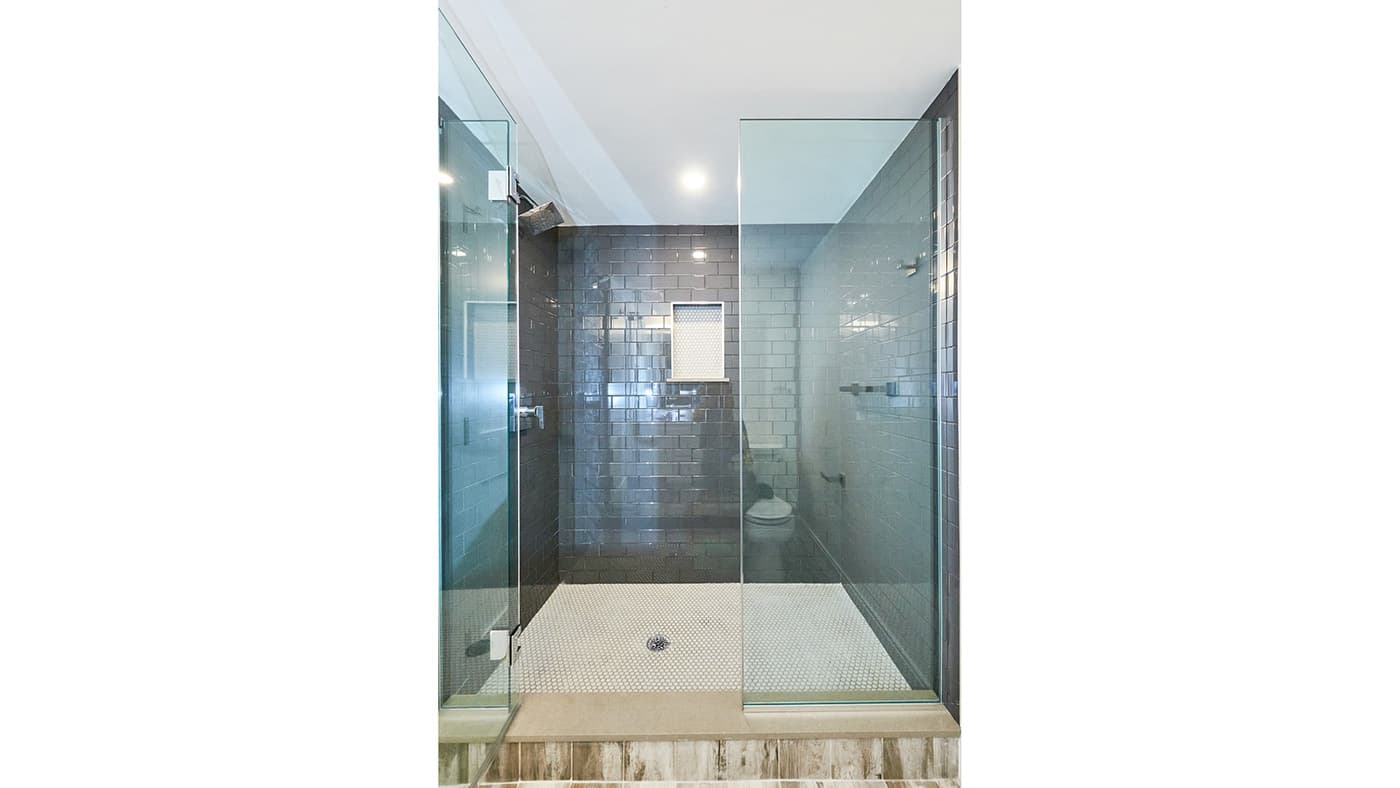 Renovated Walnut St. Newton bathroom with charcoal subway tile shower and white hexagon floor tile