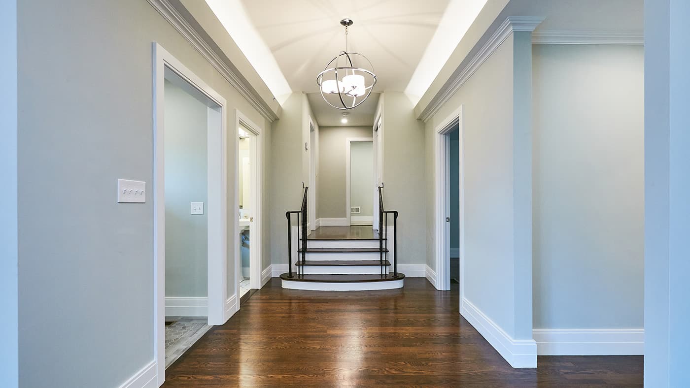 Walnut St. Newton hallway remodel with a vaulted ceiling, sphere chandelier, and dark hardwood floors