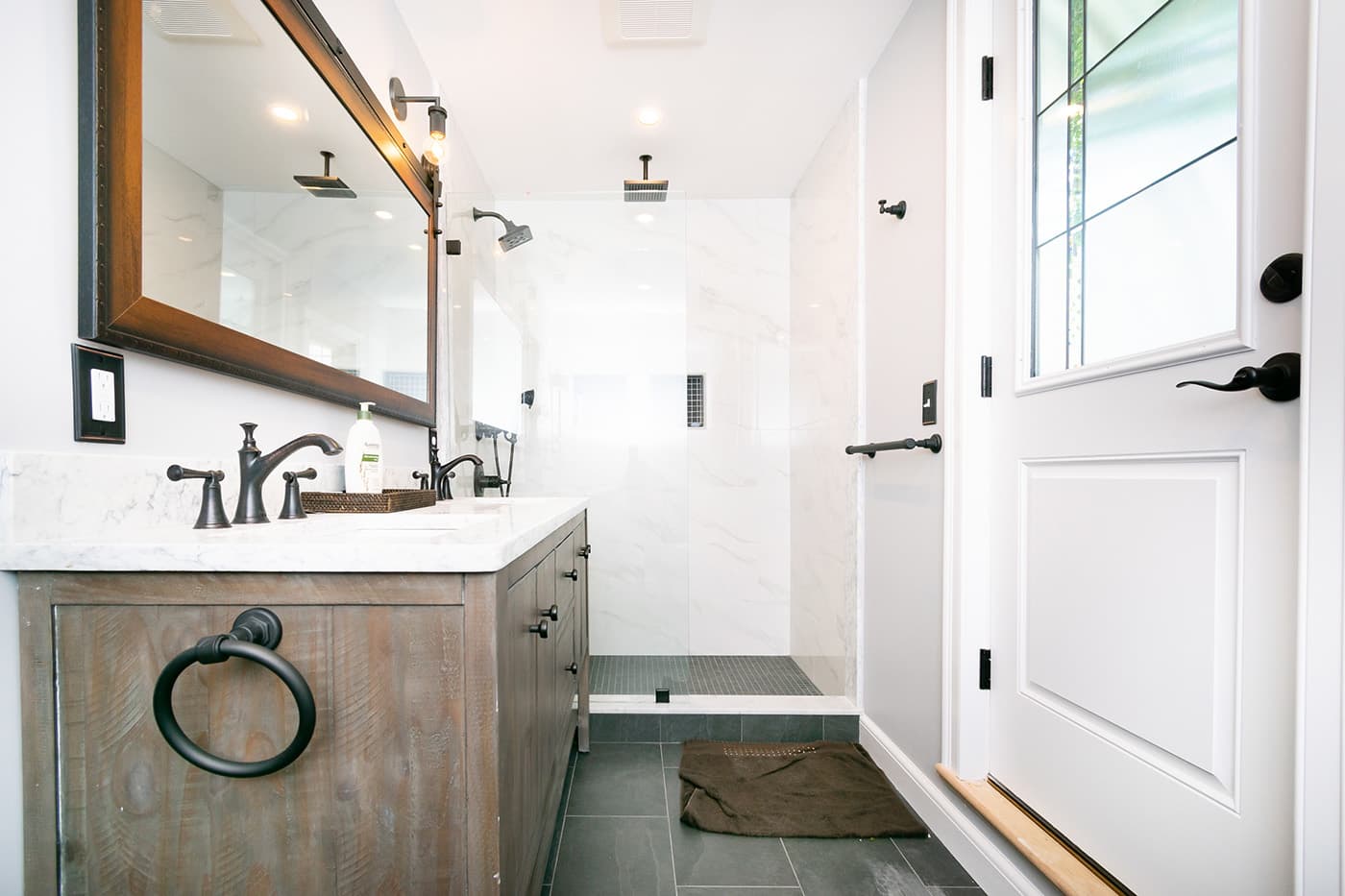 Renovated Welland Rd. Brookline bathroom with wood vanity, marble shower, and slate tile flooring