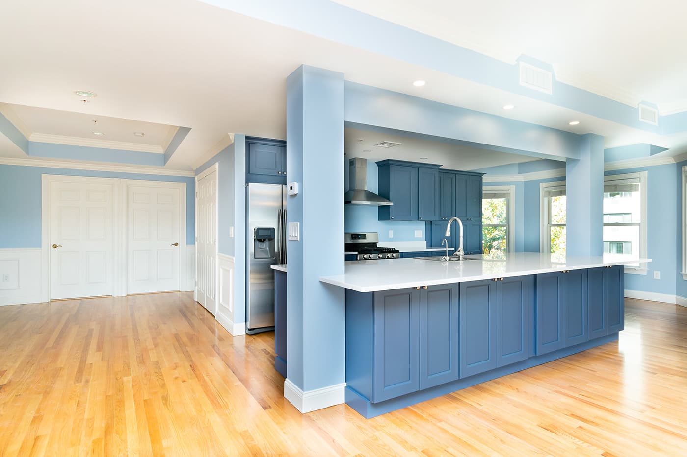 Winchester St. Brookline kitchen with slate-blue cabinets, white quartz counters, and open-concept wood flooring