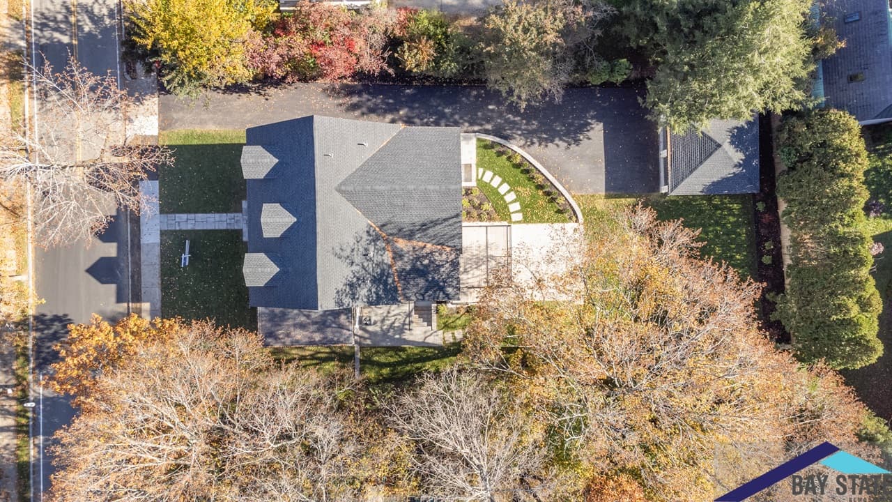 Aerial view of renovated Mill St. Newton home shows curved paver walkway and landscaped side yard
