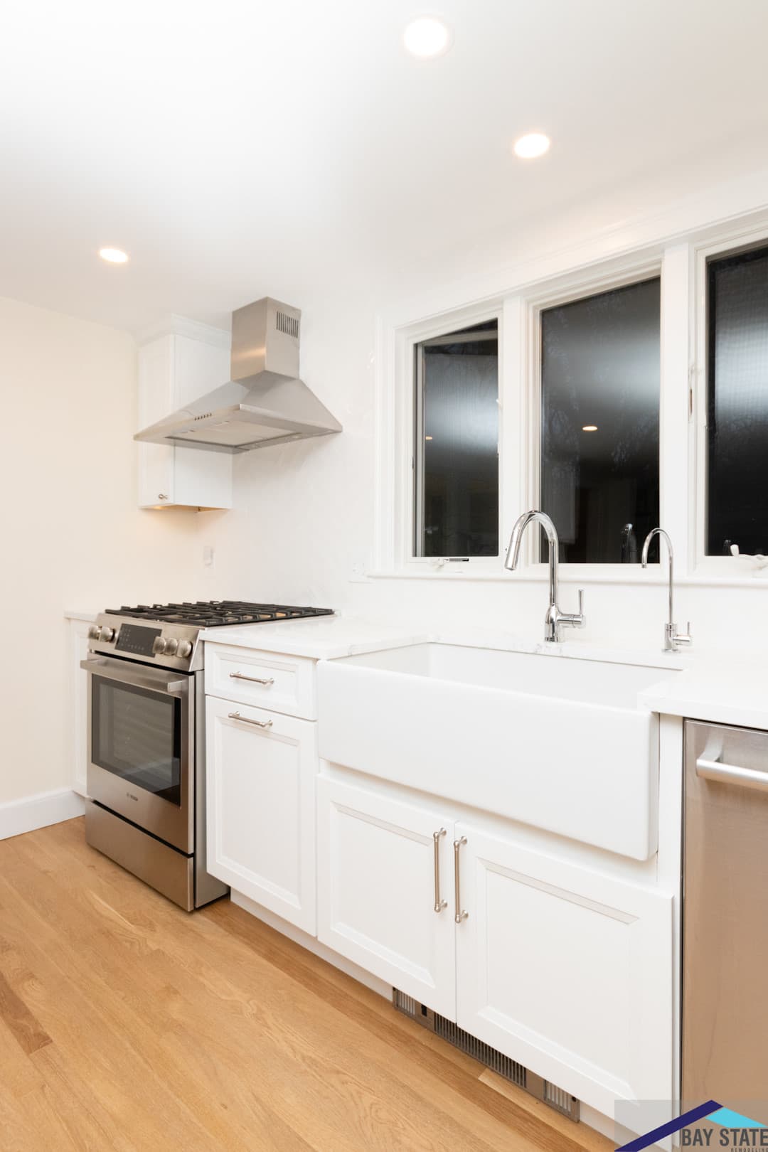 Remodeled Sun Hill Ln. Newton kitchen with gas range, stainless hood, farmhouse sink, and dual faucets