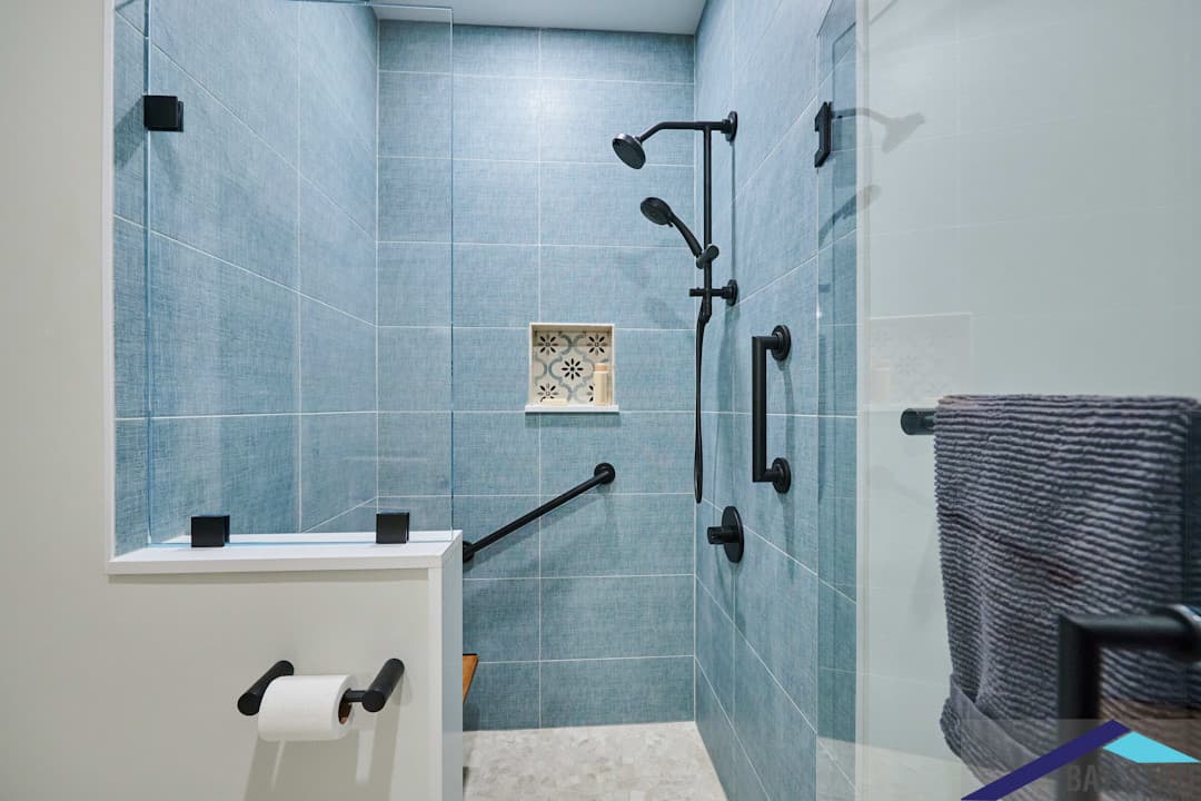 Renovated Lamartine St. Jamaica Plain bathroom with black fixtures, wood-look floor tile, and dark marble vanity