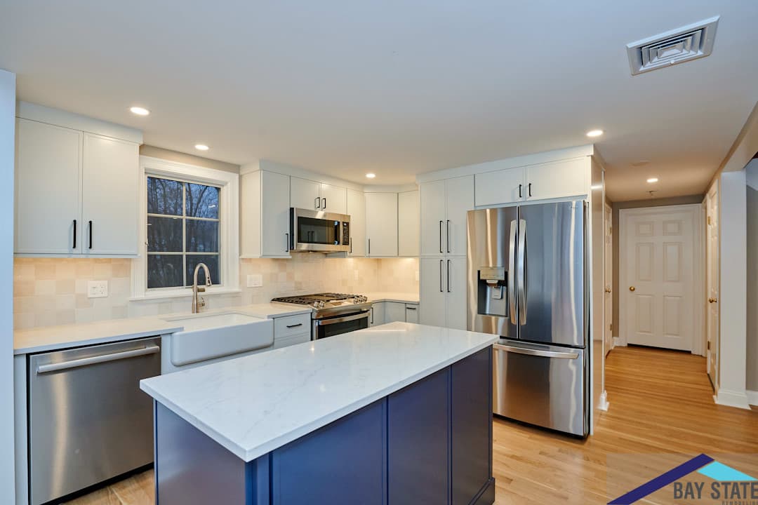 Wright St. Arlington kitchen with navy island, white perimeter cabinets, and diamond-pattern tile backsplash