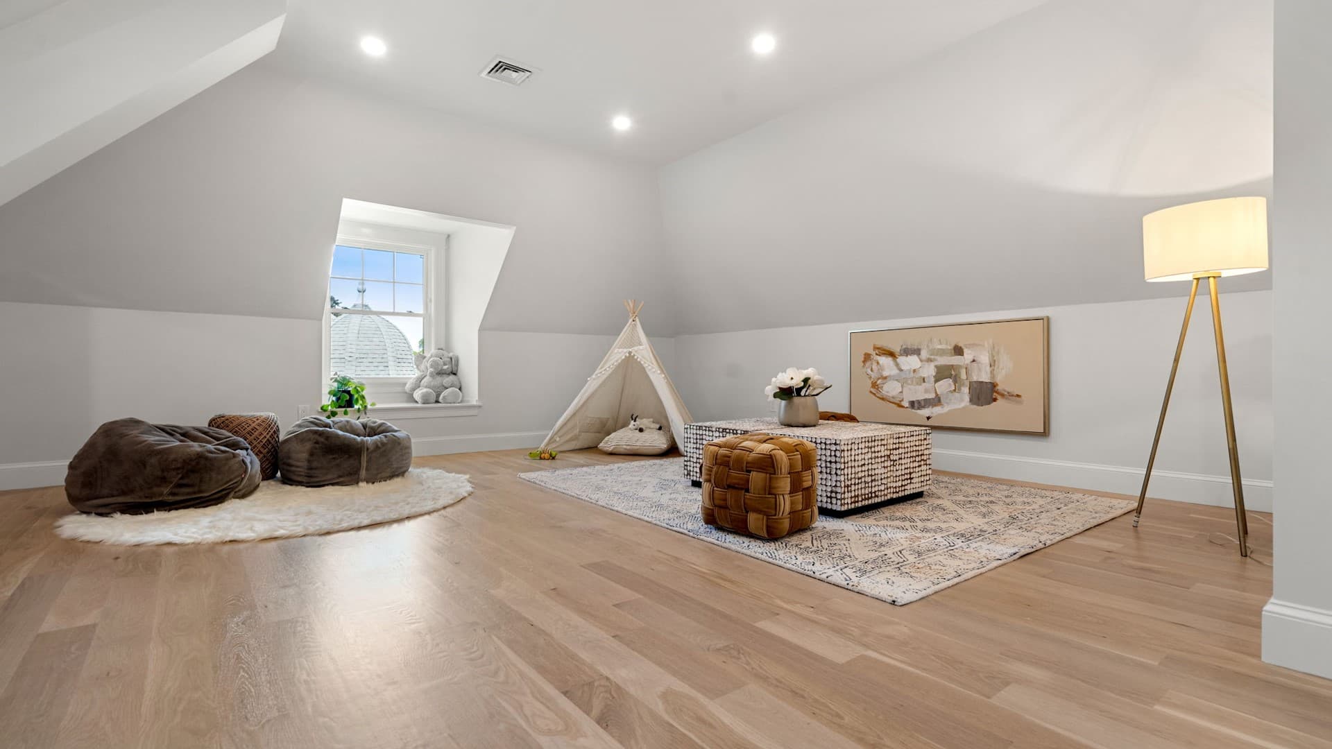 Sewall St. Newton attic converted into kids playroom with teepee tent, bean bags, and wood floors