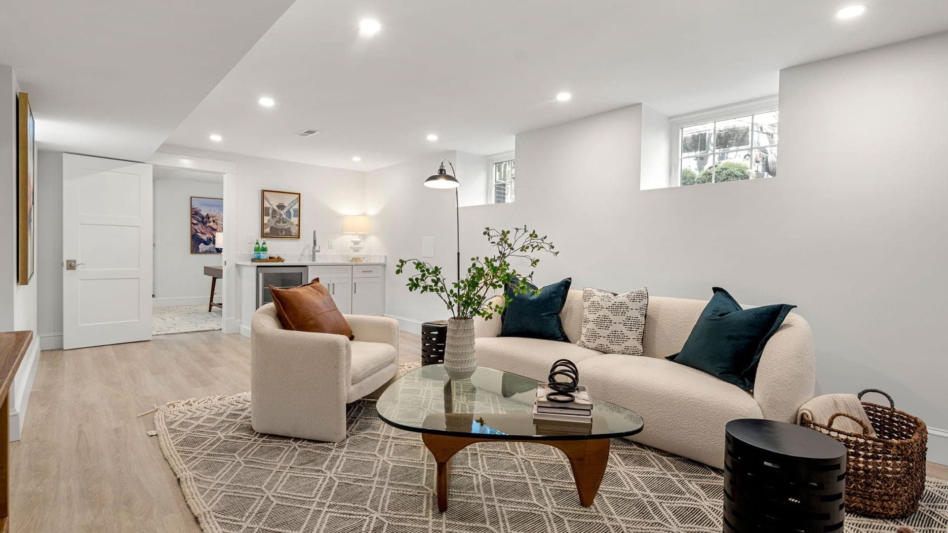 Sewall St. Newton basement lounge finished with wet bar, plush sofa, and glass coffee table