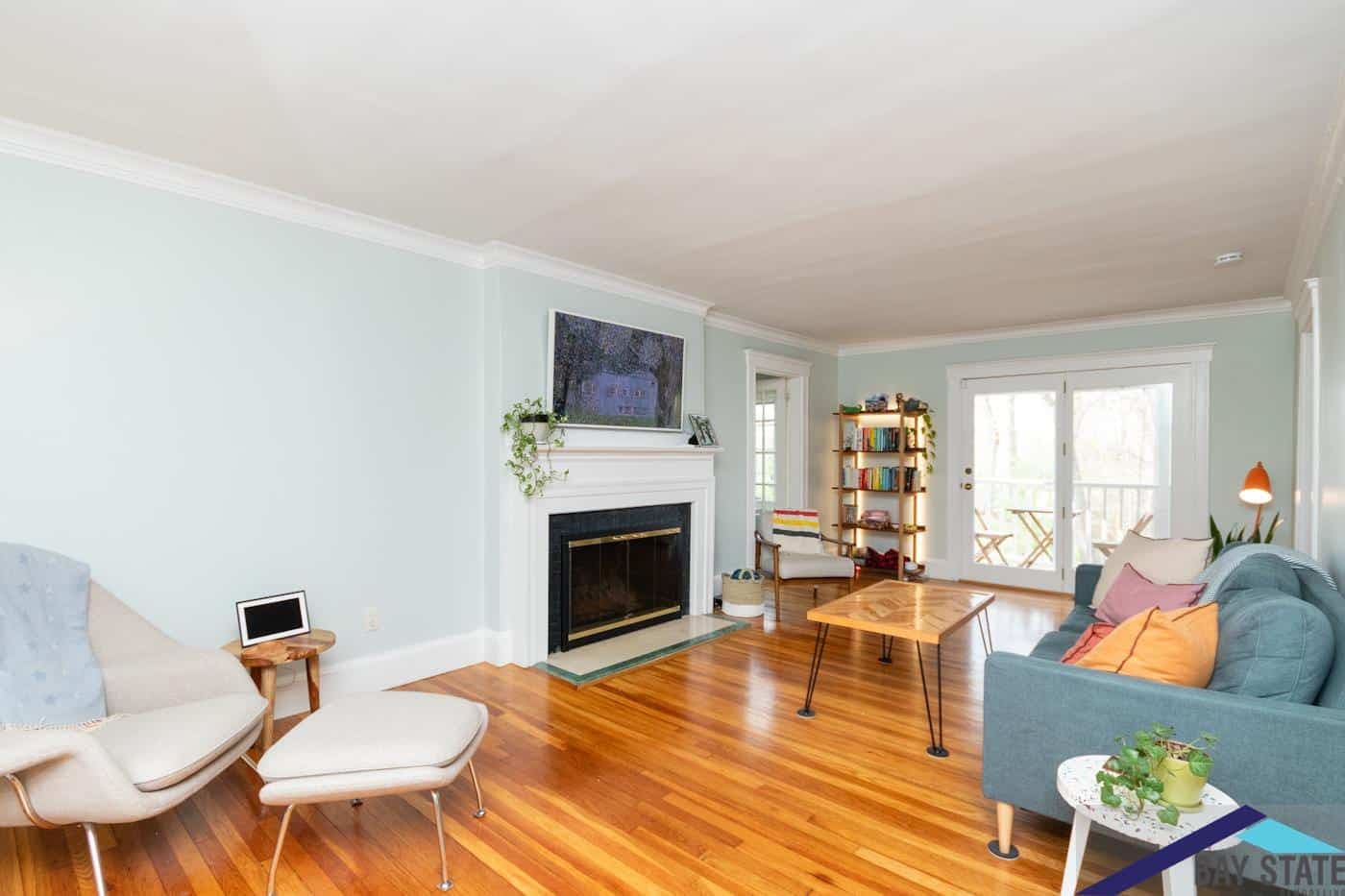 Renovated Newton living room on Trowbridge Ave. with white fireplace mantel and French doors