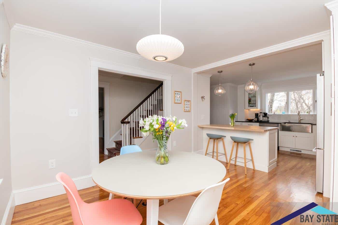 Newton kitchen on Trowbridge Ave. flows into dining nook with staircase and pendant lights