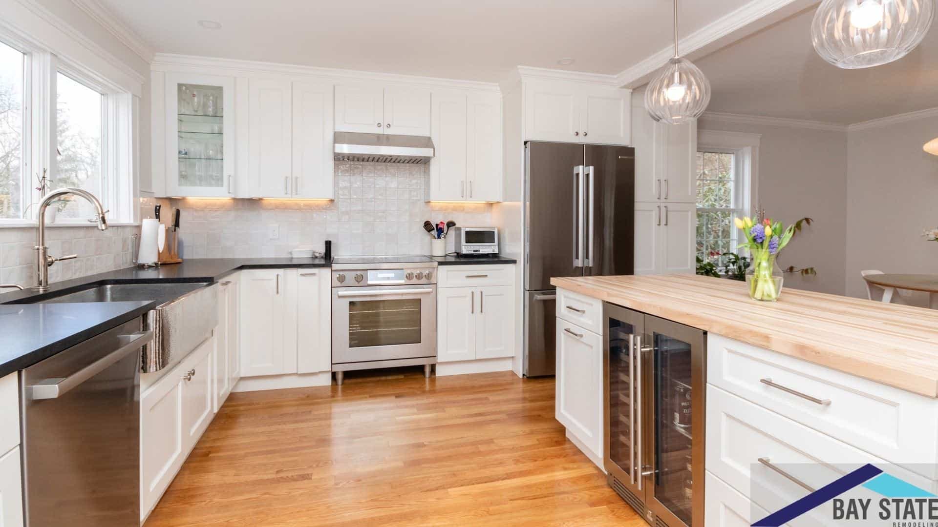 Trowbridge Ave. Newton kitchen with white cabinets, black counters, and butcher block island with wine fridge