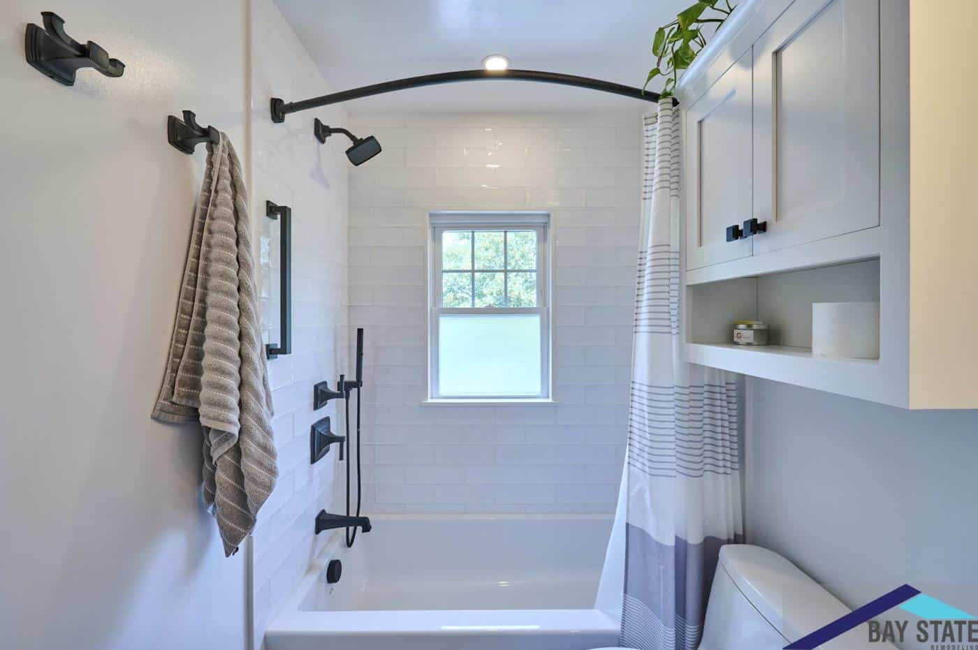 Renovated N. Crescent Circuit Boston bathroom tub and shower with curved black rod and subway tile