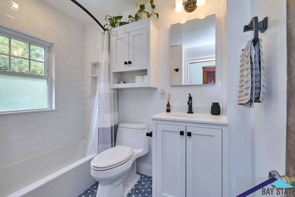 Renovated N. Crescent Circuit Brighton bathroom with white subway tile tub and patterned blue floor tile