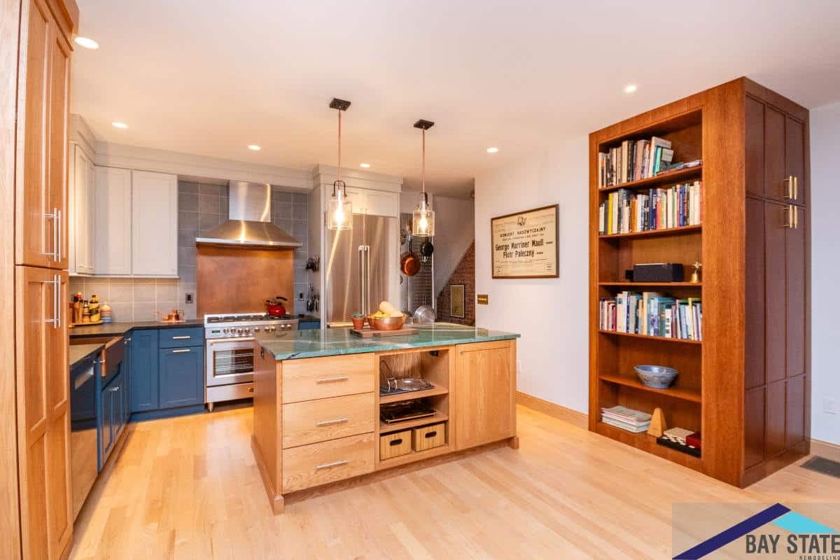 Gardner Rd. Cambridge kitchen with wood island, glass countertop, navy lower cabinets, and copper tile backsplash