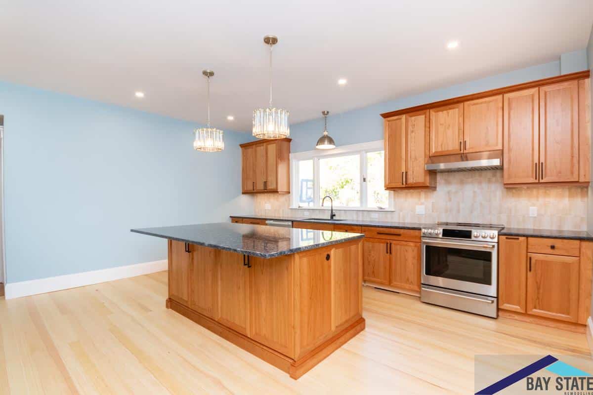 Bartlett Crescent Brookline kitchen with cherry cabinets, speckled granite island, and crystal pendant lighting