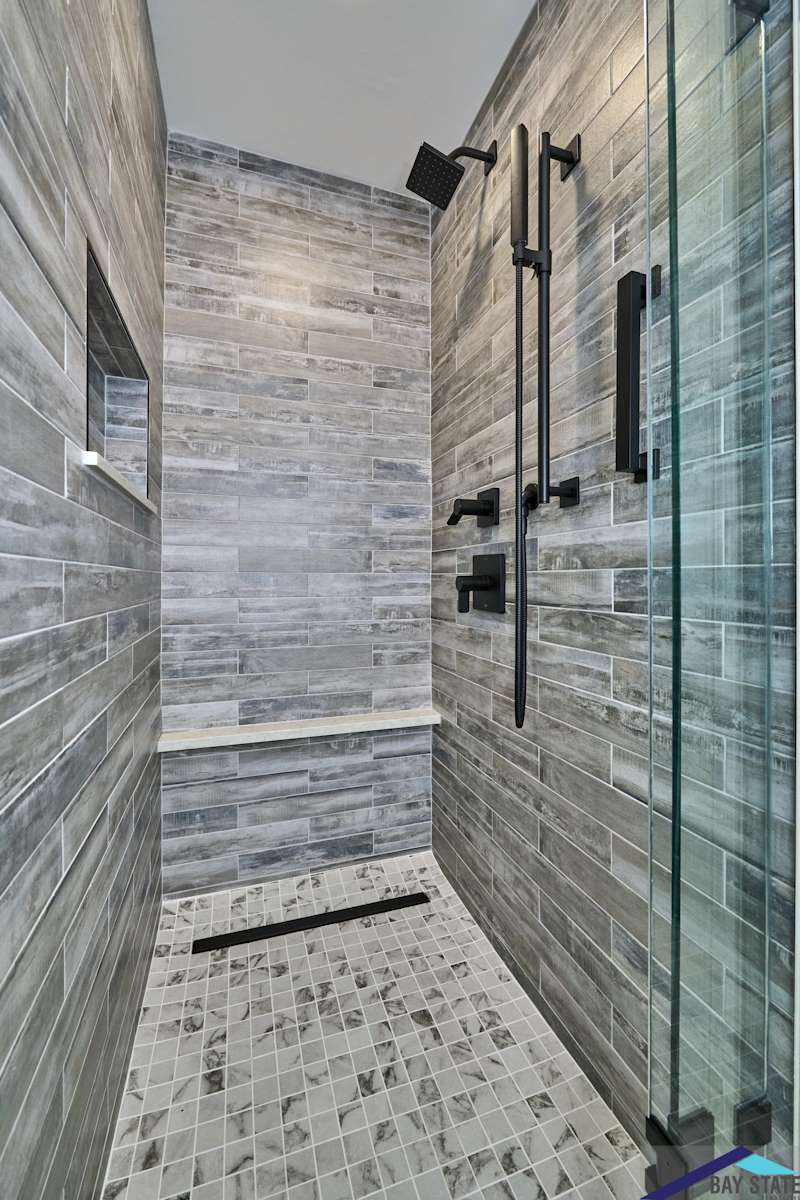 South Commons Lincoln bathroom shower with gray wood-look tile and marble mosaic floor