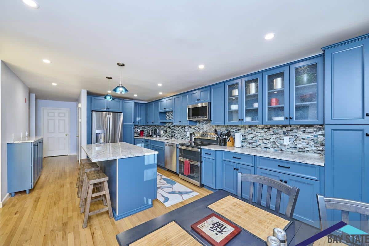 South Commons Lincoln kitchen with blue cabinets, mosaic backsplash tile, and white marble island countertop