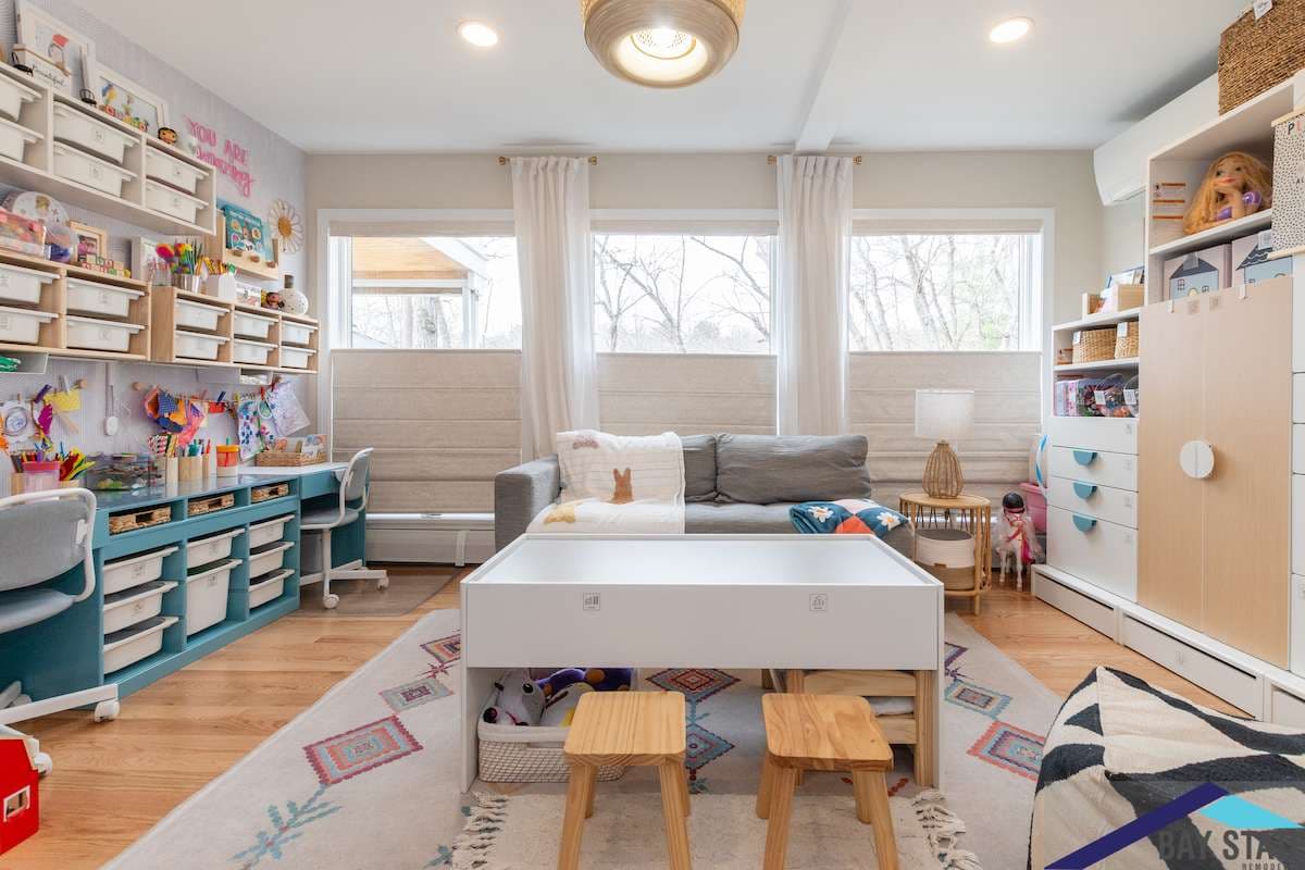 Amelia Drive Waltham playroom remodel with a teal built-in desk, white shelving, and refinished oak floors