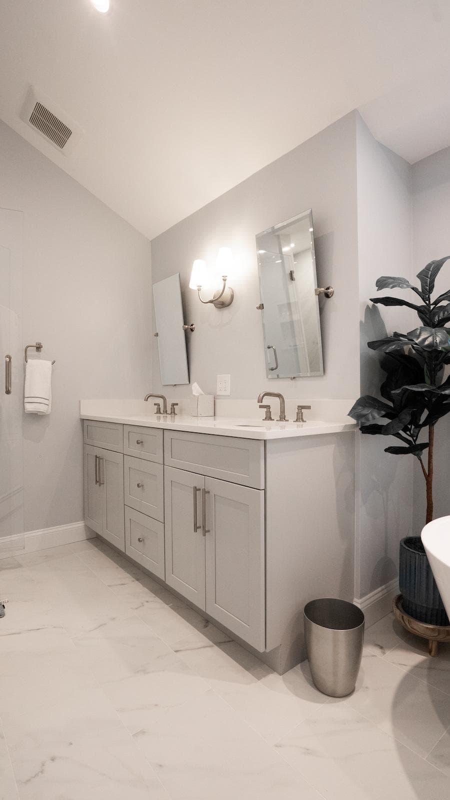 Renovated Brook Trail Rd. Wayland bathroom features gray double vanity, pivot mirrors, and wall sconce