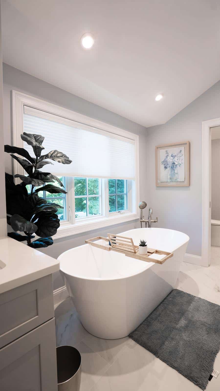 Renovated Wayland bathroom on Brook Trail Rd. shows freestanding tub beneath window with leafy plant