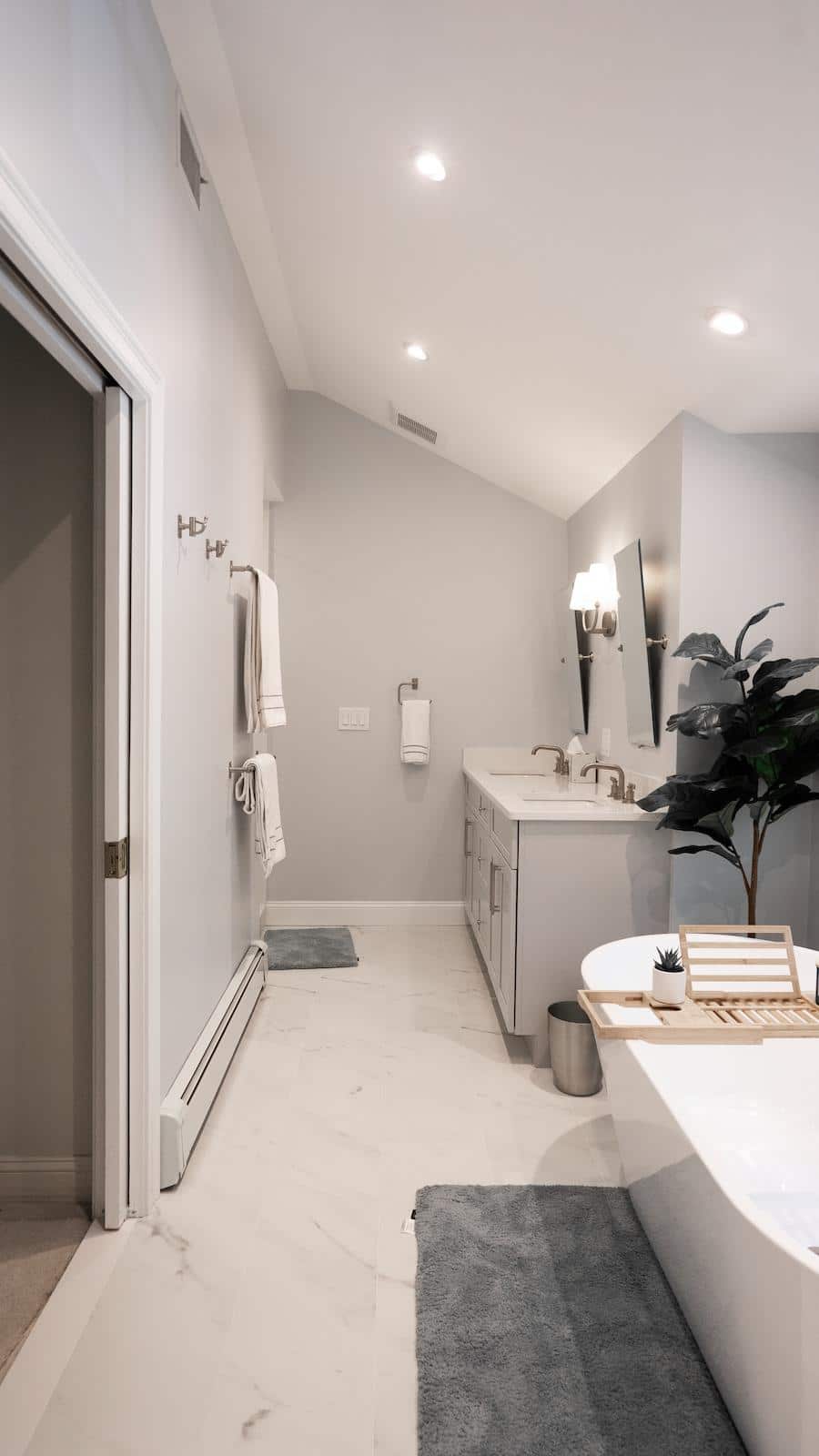 Renovated Brook Trail Rd. Wayland bathroom hallway with towel hooks, gray vanity, and marble-look floor