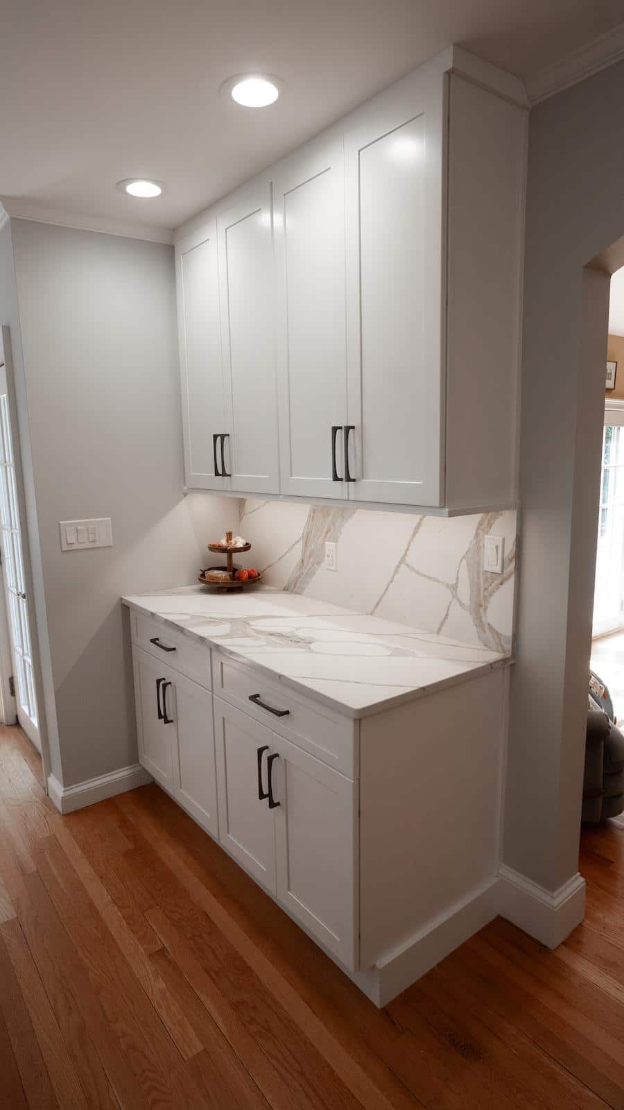 Brook Trail Rd. kitchen nook in Wayland with white cabinets, marble backsplash, and a two-tier fruit stand