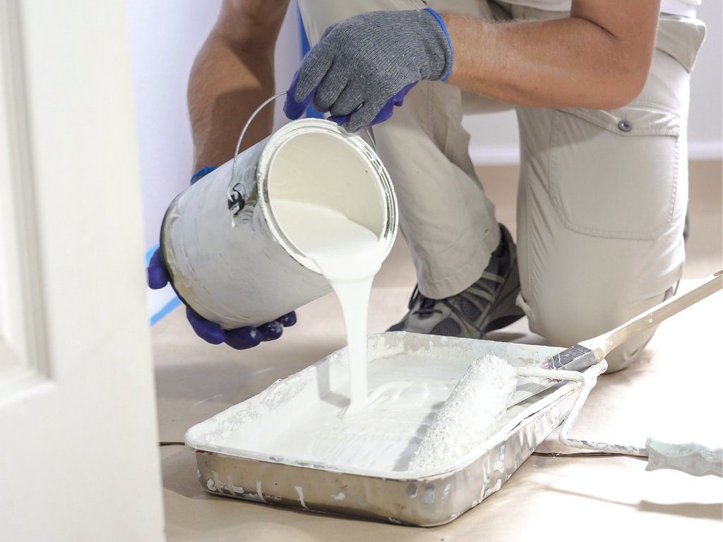 man-pours-paint-into-tray-dips