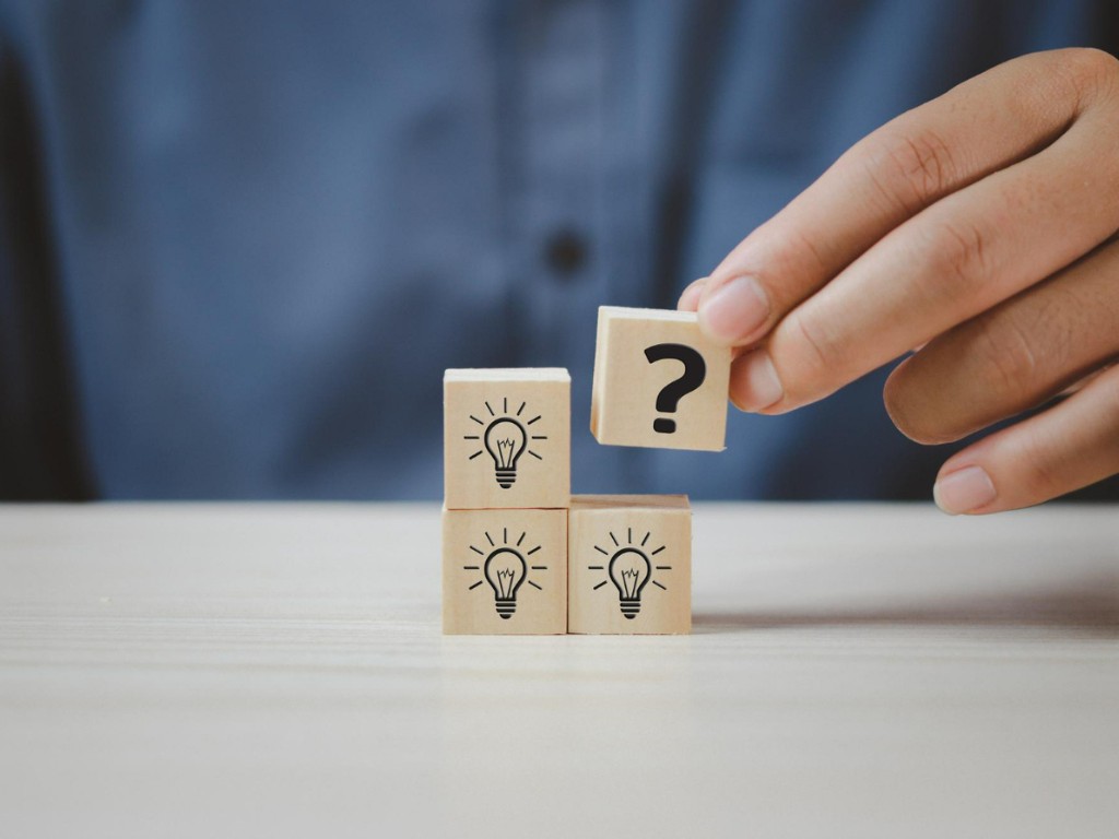 hand put wooden cubes with question mark symbol