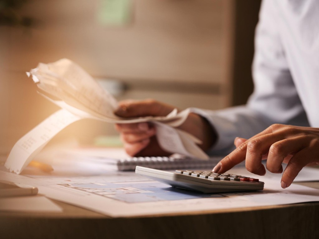 closeup-economist-using-calculator-while-going-through-bills-taxes-office
